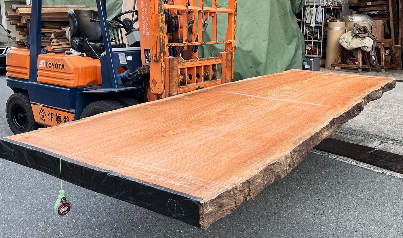 原木から切り出された無垢材の一枚板。糸を張って反りの状況や、割れ、節や虫食い、水分の含有率などを確認。